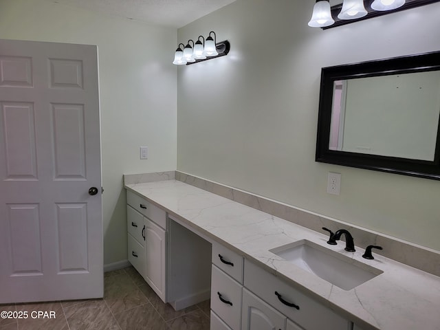 bathroom featuring marble finish floor, vanity, and a textured ceiling