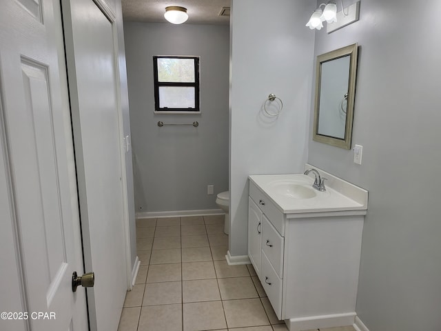 bathroom with toilet, tile patterned flooring, baseboards, and vanity