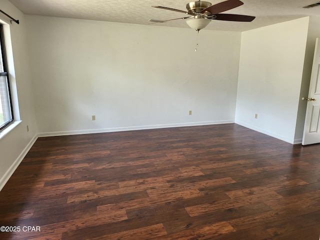 unfurnished room featuring baseboards, visible vents, ceiling fan, dark wood-type flooring, and a textured ceiling