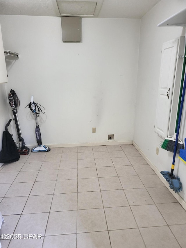 interior space featuring light tile patterned flooring and baseboards