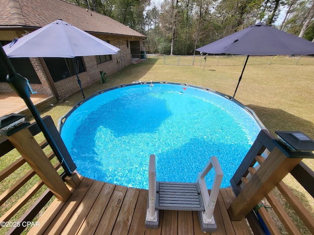 view of pool featuring a lawn, fence, and a fenced in pool