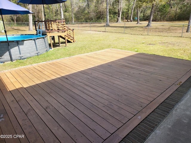 deck featuring a fenced backyard, an outdoor pool, and a yard