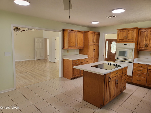 kitchen featuring white appliances, visible vents, ceiling fan, light countertops, and light tile patterned flooring