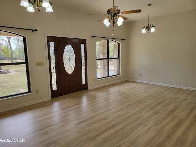 foyer featuring light wood-style floors, a healthy amount of sunlight, and a notable chandelier