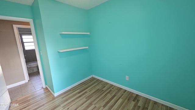 empty room featuring baseboards and wood finished floors