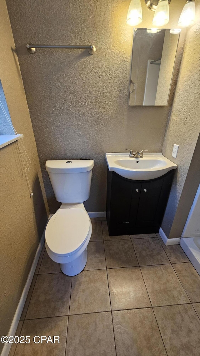 bathroom featuring tile patterned flooring, vanity, and toilet