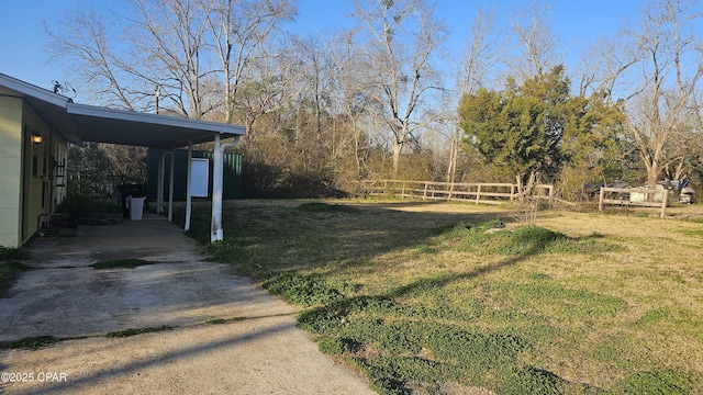 view of yard with driveway, fence, and an attached carport