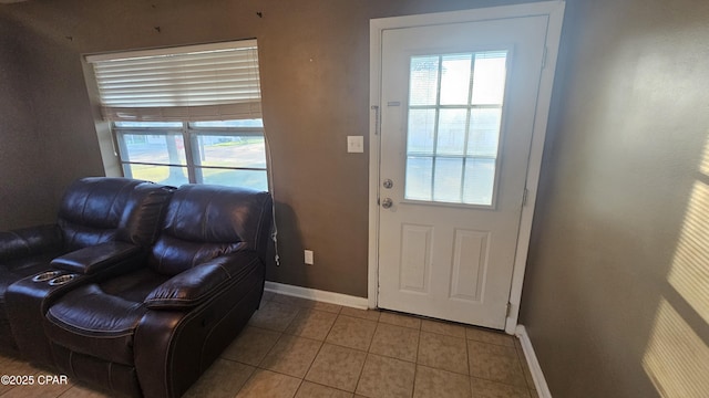 doorway to outside with baseboards and tile patterned floors