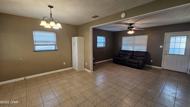 interior space with a textured ceiling, baseboards, and a wealth of natural light