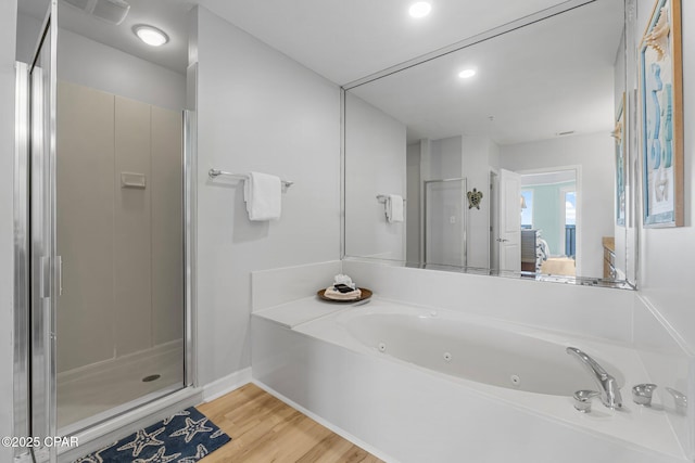 ensuite bathroom featuring visible vents, wood finished floors, ensuite bathroom, a jetted tub, and a shower stall