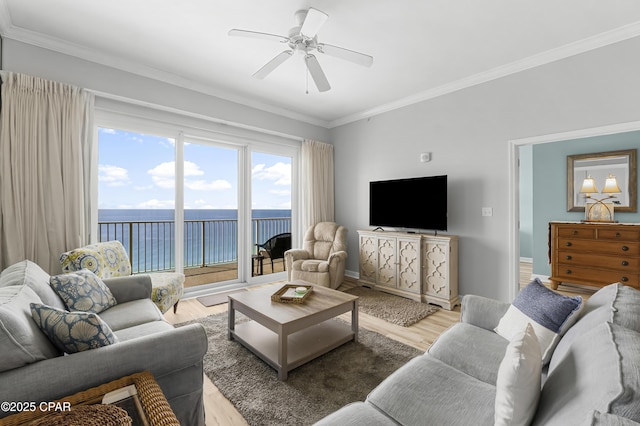 living room featuring light wood-style floors, crown molding, baseboards, and a ceiling fan