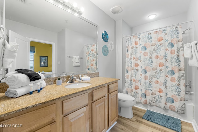 full bathroom with shower / tub combo, vanity, toilet, and wood finished floors