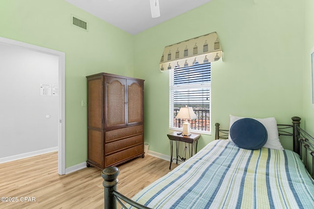 bedroom featuring light wood-style floors, baseboards, visible vents, and ceiling fan