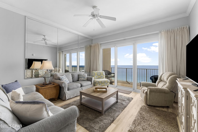 living area with ornamental molding, light wood-style floors, and ceiling fan