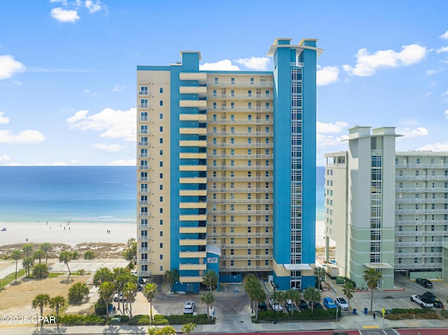 view of property with a water view and a view of the beach