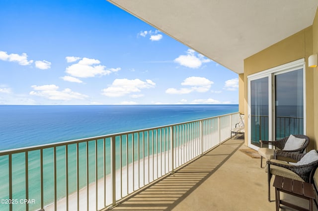 balcony featuring a water view and a beach view