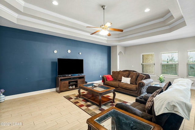 living room with arched walkways, a raised ceiling, crown molding, and light wood-style flooring