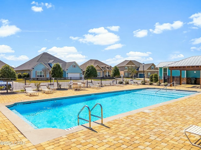 pool featuring a patio, fence, and a residential view