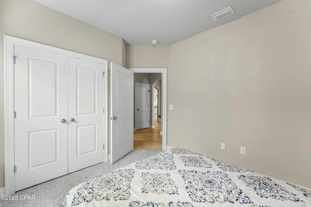 bedroom with light speckled floor, a closet, and visible vents