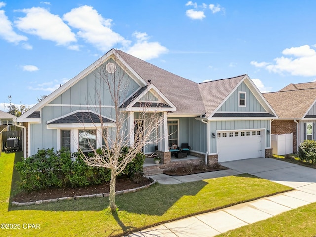 view of front of house featuring a garage, a shingled roof, concrete driveway, a front lawn, and board and batten siding