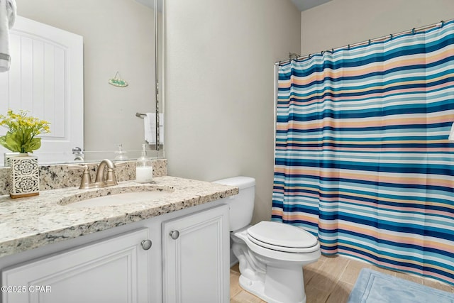 full bath with toilet, a shower with shower curtain, wood finished floors, and vanity