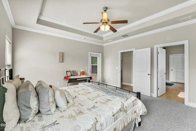 bedroom featuring ornamental molding, a raised ceiling, and visible vents