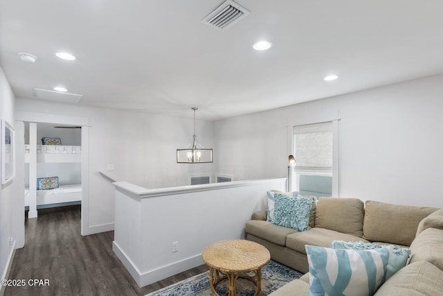 living area with visible vents, baseboards, dark wood finished floors, recessed lighting, and a notable chandelier