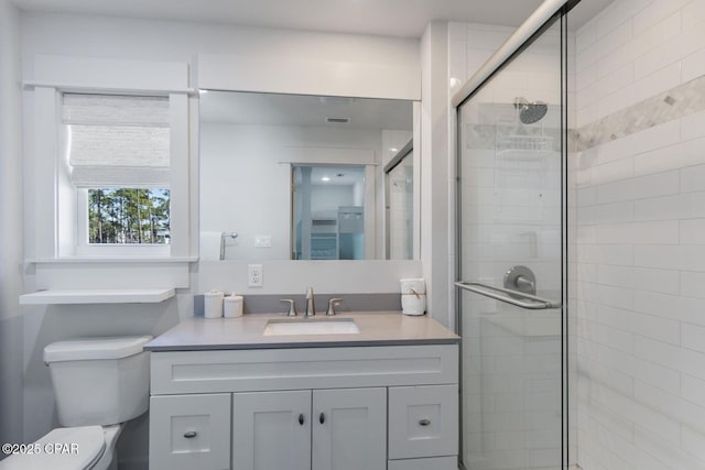 full bathroom with toilet, a stall shower, and vanity