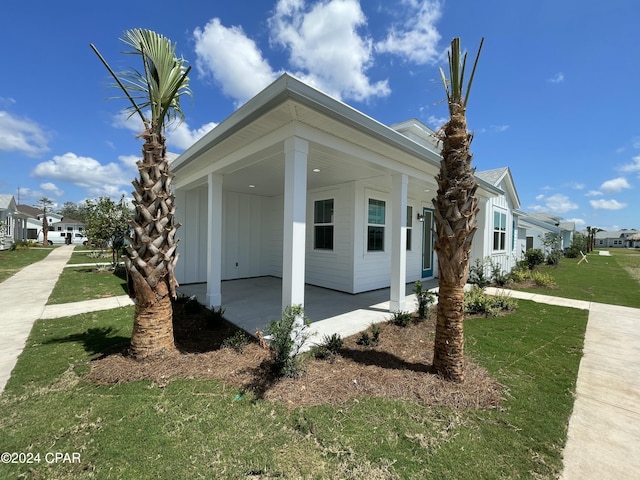 view of side of property with a lawn