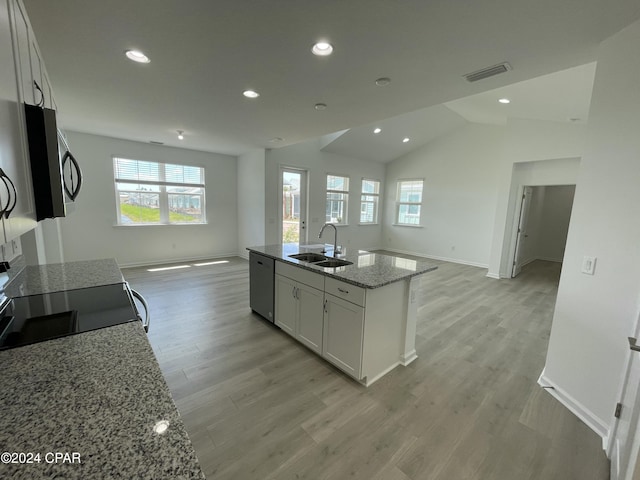 kitchen with stainless steel appliances, visible vents, open floor plan, white cabinets, and a sink