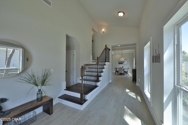146 Bayou Manor Rd, Santa Rosa Beach, FL 32459 - foyer entrance featuring stairway, light wood-type flooring, high vaulted ceiling, baseboards, and visible vents