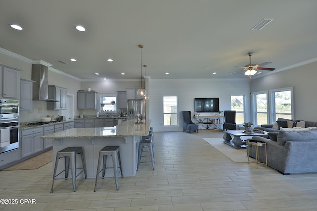 146 Bayou Manor Rd, Santa Rosa Beach, FL 32459 - kitchen with gray cabinetry, open floor plan, stainless steel appliances, wall chimney range hood, and visible vents