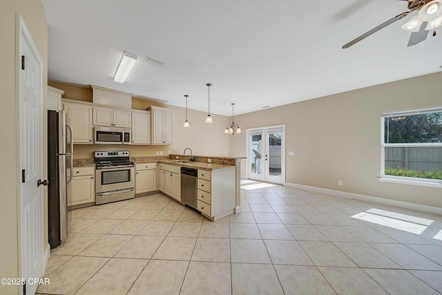 kitchen with light tile patterned floors, ceiling fan, a peninsula, appliances with stainless steel finishes, and open floor plan