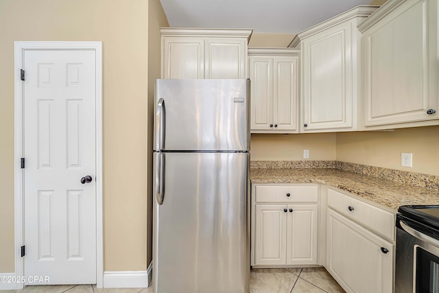 kitchen with light tile patterned flooring, light stone counters, and stainless steel appliances