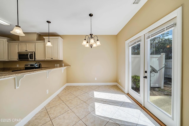 kitchen featuring a kitchen breakfast bar, pendant lighting, stainless steel appliances, and baseboards