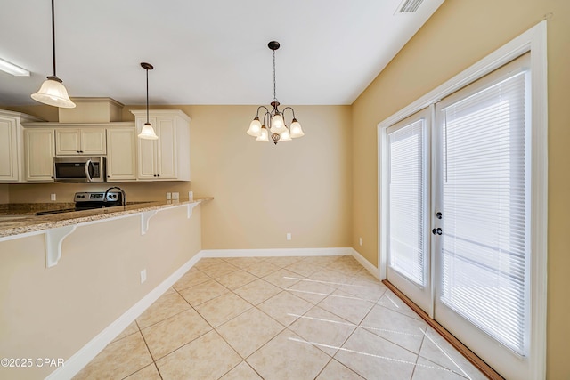 kitchen with appliances with stainless steel finishes, a breakfast bar area, a healthy amount of sunlight, and french doors