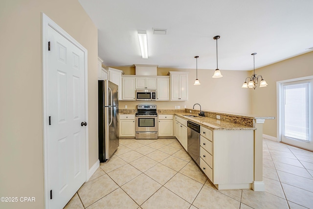 kitchen featuring light tile patterned floors, a sink, visible vents, stainless steel appliances, and a peninsula