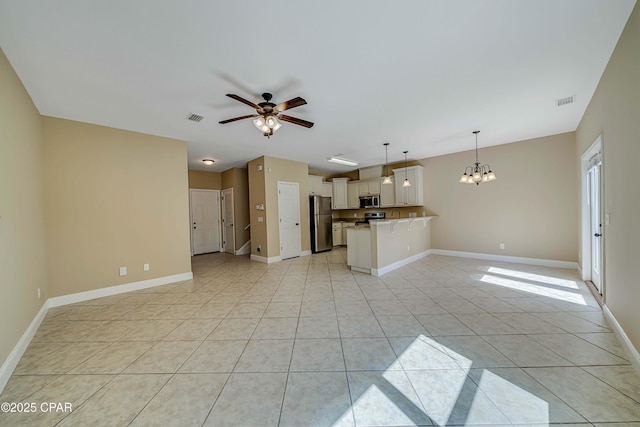 unfurnished living room featuring light tile patterned flooring, visible vents, baseboards, and ceiling fan with notable chandelier