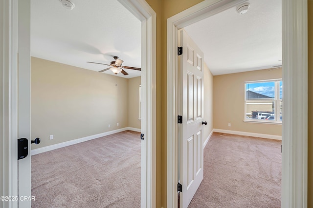 hall with baseboards and carpet floors