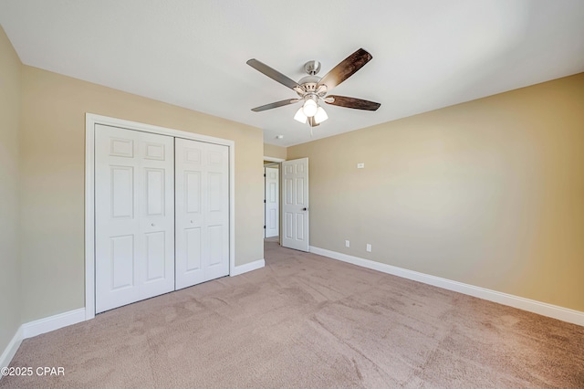 unfurnished bedroom featuring baseboards, a ceiling fan, carpet floors, and a closet