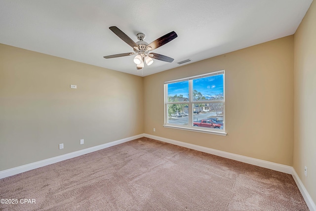 spare room with a ceiling fan, visible vents, carpet, and baseboards
