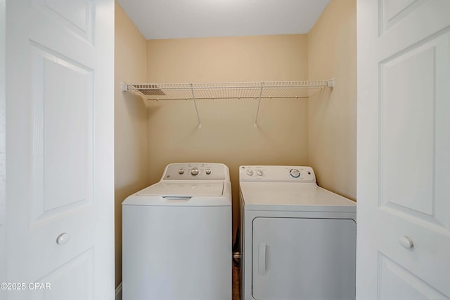 laundry area with washing machine and clothes dryer and laundry area