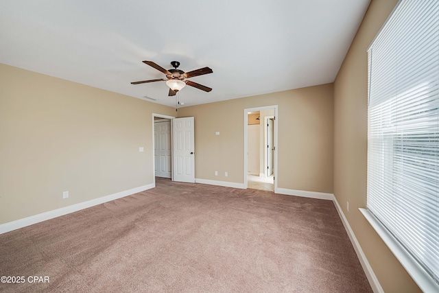 empty room with baseboards, visible vents, ceiling fan, and carpet floors