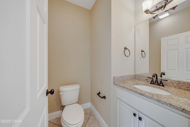 half bathroom with tile patterned floors, vanity, toilet, and baseboards