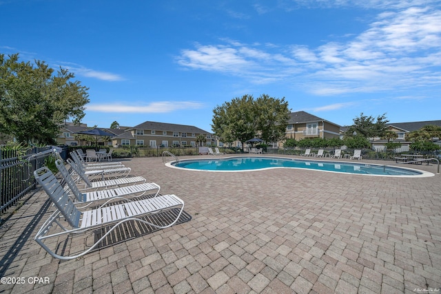 pool with a residential view, fence, and a patio area