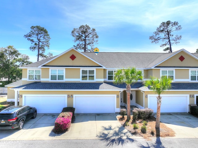 multi unit property with an attached garage, driveway, and stucco siding