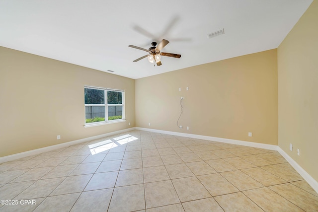 unfurnished room with light tile patterned flooring, visible vents, a ceiling fan, and baseboards
