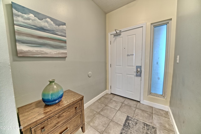 foyer with light tile patterned floors and baseboards