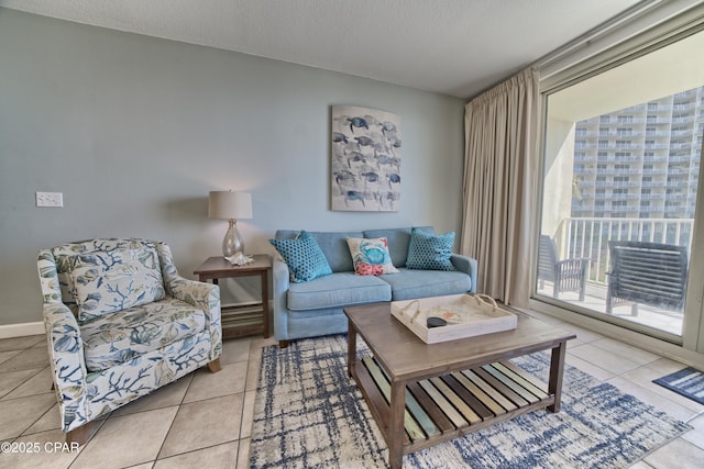 living room featuring tile patterned floors, visible vents, baseboards, and a textured ceiling