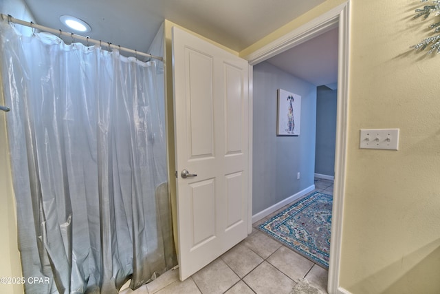 bathroom with baseboards, a shower with curtain, and tile patterned flooring